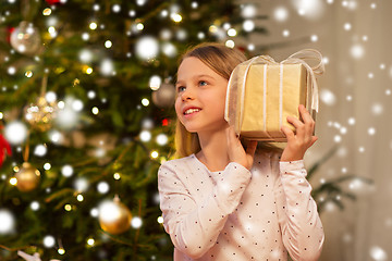 Image showing smiling girl with christmas gift at home