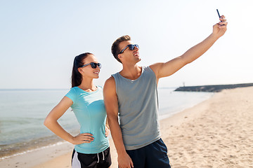 Image showing couple taking selfie by smartphone on beach