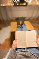 Image showing close up of young man reading book at home