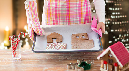 Image showing woman with gingerbread house parts on oven tray