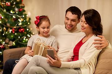 Image showing family with smartphone at home on christmas