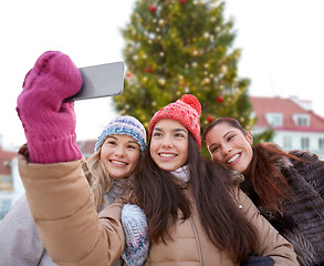 Image showing teenage girls taking selfie over christmas tree