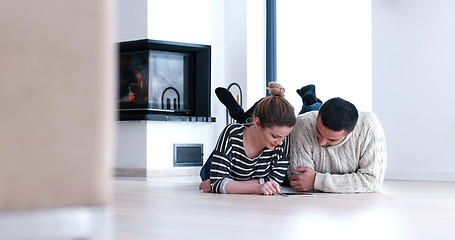 Image showing Young Couple using digital tablet on the floor