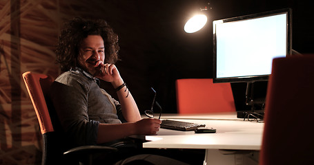 Image showing man working on computer in dark office