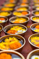 Image showing Buddhist flower offerings or gifts in bowls and rows