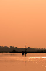 Image showing Men in a boat on a river silhouette