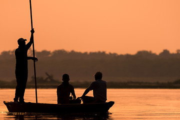 Image showing Men in a boat on a river silhouette