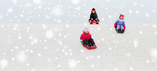 Image showing kids sliding on sleds down snow hill in winter