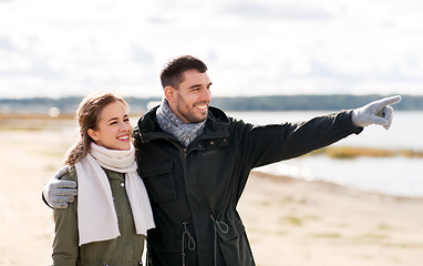 Image showing smiling couple hugging on autumn beach