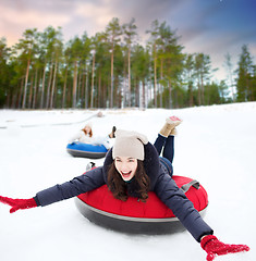 Image showing happy teenage girl sliding down hill on snow tube