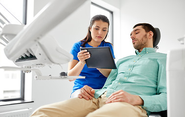 Image showing dentist and patient with tablet pc at clinic