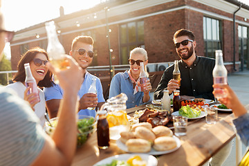 Image showing happy friends with drinks or bbq party on rooftop