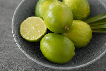 Image showing close up of limes in bowl on slate table top