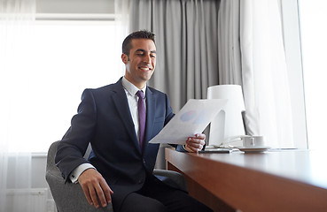 Image showing businessman with papers working at hotel room