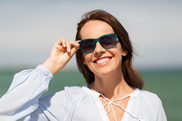 Image showing happy smiling woman in sunglasses on summer beach