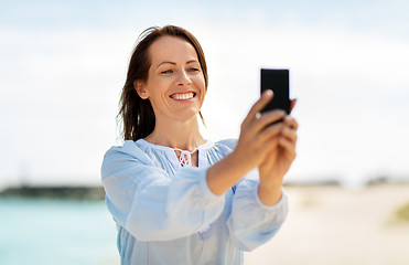 Image showing happy smiling woman taking selfie on summer beach