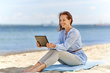 Image showing happy smiling woman with tablet pc on summer beach