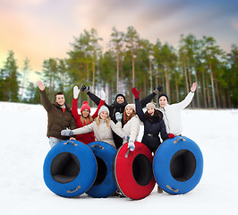 Image showing happy friends with snow tubes outdoors in winter