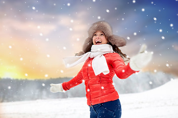 Image showing happy woman in fur hat over winter background