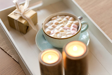 Image showing hot chocolate, christmas gift and candles on table