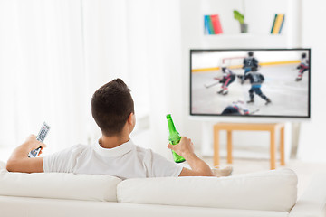 Image showing man watching ice hockey on tv and drinking beer