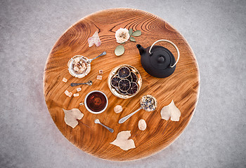 Image showing Tea, flowers and sweets on round wooden table