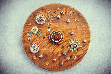 Image showing Vintage wooden table with tea and floral decor