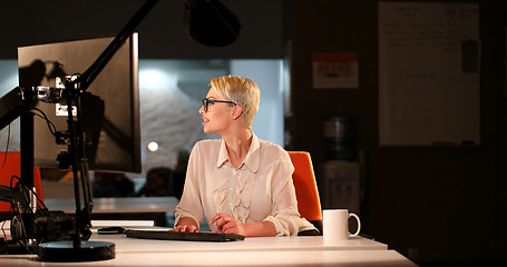 Image showing woman working on computer in dark office