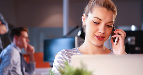 Image showing woman using mobile phone in dark office