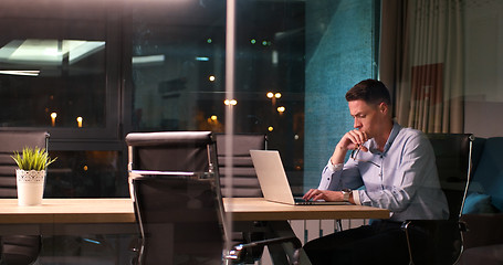 Image showing man working on laptop in dark office