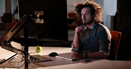 Image showing man working on computer in dark office