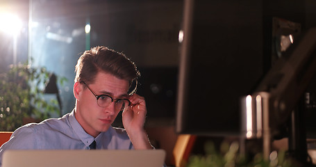 Image showing man working on computer in dark office