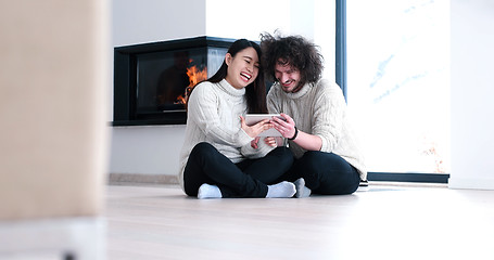 Image showing Young Couple using digital tablet on the floor