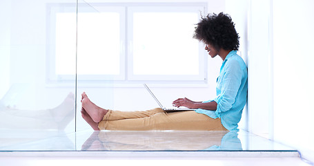 Image showing black women using laptop computer on the floor