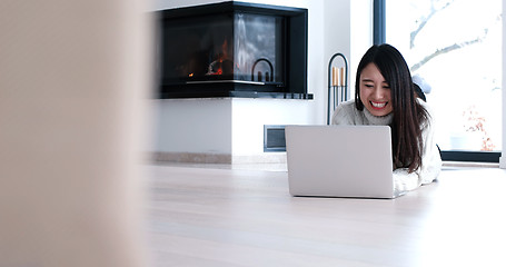 Image showing Asian woman using laptop on floor