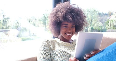 Image showing african american woman at home using digital tablet