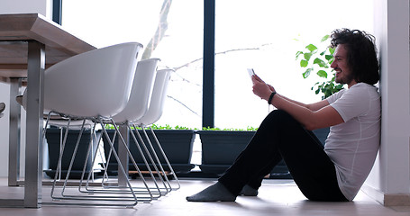 Image showing young man using a tablet at home