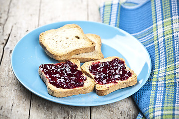 Image showing Fresh toasted cereal bread slices with homemade wild berries jam