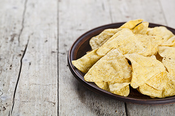 Image showing Nachos chips on brown ceramic plate. 