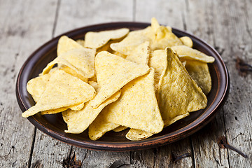 Image showing Nachos chips on brown ceramic plate. 