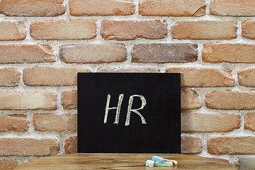 Image showing Chalk board with the word HR drown by hand and chalks on wooden 