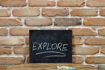 Image showing Chalk board with the word EXPLORE drown by hand and chalks on wo