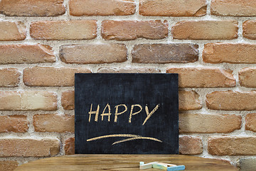 Image showing Chalk board with the word HAPPY drown by hand and chalks on wood