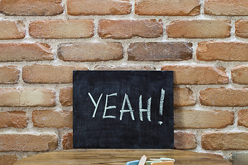 Image showing Chalk board with the word YEAH! drown by hand and chalks on wood