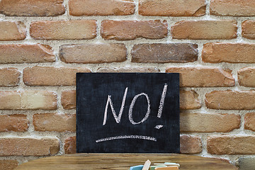 Image showing Chalk board with the word NO! drown by hand and chalks on wooden