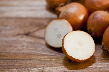 Image showing Organic fresh  onions heap closeup on rustic wooden table backgr
