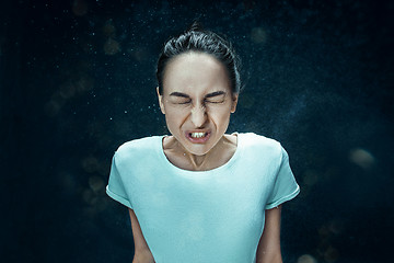 Image showing Young woman sneezing, studio portrait