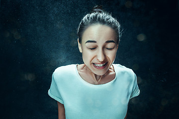 Image showing Young woman sneezing, studio portrait