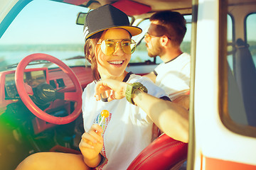 Image showing Laughing romantic couple sitting in car while out on a road trip at summer day