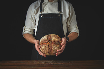 Image showing fresh round bread male hands holding